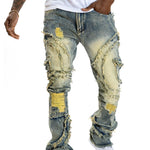 Men's patchwork fringe slightly flared stretch jeans in blue denim with distressed details and trendy rips.