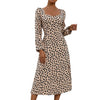 Person wearing a leopard print dress against a plain background