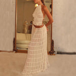 Model showcasing a sexy backless halter top and pleated long dress in white, perfect for social events.