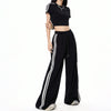 Black wide-leg casual pants with white stripes and matching cropped top for a sporty look.