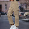 Women's high waist loose casual working pants in khaki with pockets, styled with sneakers in urban setting.