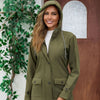 Stylish woman wearing an olive green waterproof anorak jacket with a hood, featuring a medium length and cozy design.