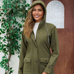 Stylish woman wearing an olive green waterproof anorak jacket with a hood, featuring a medium length and cozy design.