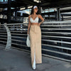 Woman in a white top and khaki skirt posing in an urban setting, showcasing summer fashion trends.