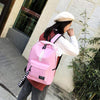 Fashionable pink canvas backpack with stylish lettering, ideal for school and urban use.