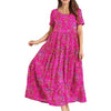 Woman wearing a vibrant pink Pleated Floral Swing Dress with short sleeves and full-length pleated skirt.