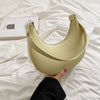 Stylish yellow crescent moon shoulder bag held on white fabric, showcasing its sleek design and urban simplicity.