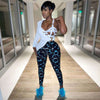 Stylish model wearing trendy black and blue printed leggings paired with a chic white top and blue feather heels.