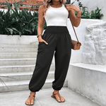 Elasticated high-waisted wide-legged niners in black, featuring long sleeves and pockets, worn casually outdoors.