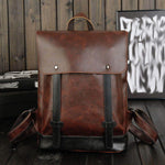 Brown PU leather clamshell backpack with shoulder straps, ideal for travel and outdoor use, featuring stylish belt decoration.