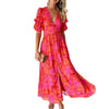 Woman wearing a vibrant floral Hand-Painted Print V-Neck Midi Dress with short sleeves, holding a clutch.
