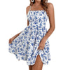 Woman wearing Floral Tube-Top Ruffle Cake Dress, white with blue floral print, sleeveless, with high-waist and tiered skirt.