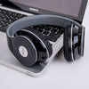 Sports headphones resting on a laptop, featuring a sleek black design and cushioned ear pads for comfort.