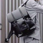 Stylish high-grade unisex black backpack with gray flap, perfect for travel and leisure activities.