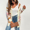Women's long camouflage knit cardigan in pink, gray, and army green, styled with a white tank and jeans.