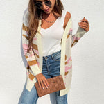 Women's long camouflage knit cardigan in pink, gray, and army green, styled with a white tank and jeans.