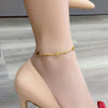 Gold flower design anklet made of titanium steel displaying elegant charm on a woman's ankle.