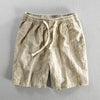 Men's casual cropped pants in light brown cotton linen with elastic waistband and loose fit design.