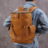 Men's large capacity brown leather backpack, solid color, ideal for leisure travel and stylish retro design.