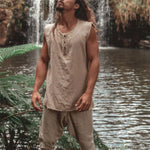 Men's loose solid color vest in linen, casual style, round hem, suitable for leisure activities near a waterfall.