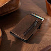 Men's ultra-thin RFID anti-theft metal card sleeve wallet in brown leather on wooden table.