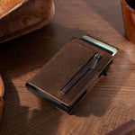 Men's ultra-thin RFID anti-theft metal card sleeve wallet in brown leather on wooden table.
