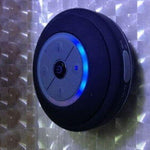 Mini waterproof LED speaker with Bluetooth, built-in mic, and high-quality sound on a textured background.