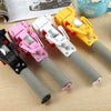 Four colorful panoramic PTZ selfie sticks in black, pink, white, and yellow on a wooden table.