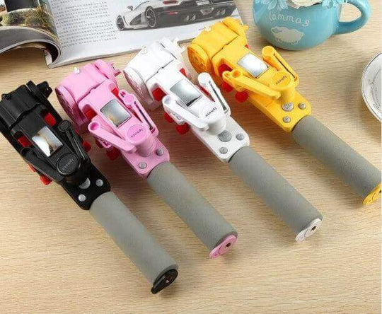 Four colorful panoramic PTZ selfie sticks in black, pink, white, and yellow on a wooden table.