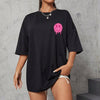 Trendy loose black women's short sleeve t-shirt featuring a pink emoji drawing, perfect for casual wear.