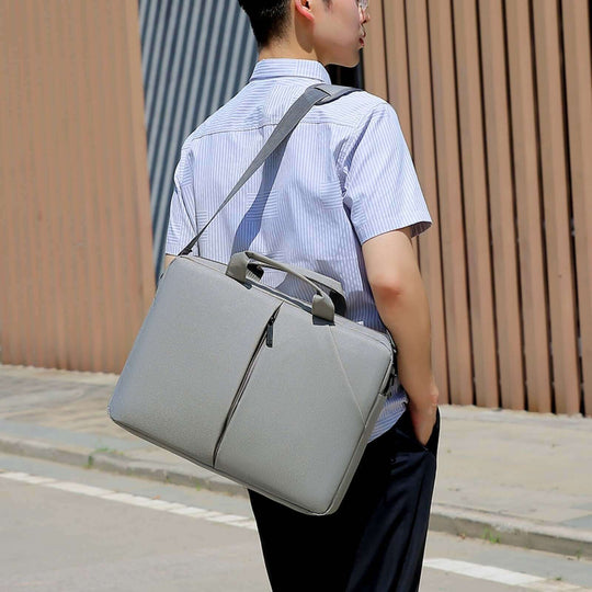 Portable laptop bag in gray, designed for cross-body wear, showcasing waterproof Oxford cloth material.