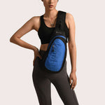 Model showcasing a blue sports shoulder bag designed for leisure travel, featuring a waterproof nylon material.
