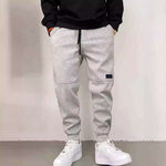 Casual gray drawstring trousers made of thick velveteen, perfect for leisure. Ideal for young, comfortable style.