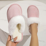 Stylish pink plush slippers with fluffy white trim, perfect for cozy indoor wear at home.