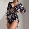 Women's black and white geometric print swimsuit with cover-up, showcasing a trendy summer look.