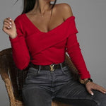 Women's red slim cross V-neck T-shirt worn with jeans, showcasing a trendy off-shoulder style in a fashionable setting.