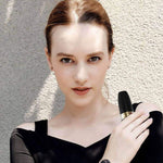Woman holding a black USB rechargeable women's hair remover, showcasing its sleek design and ease of use.