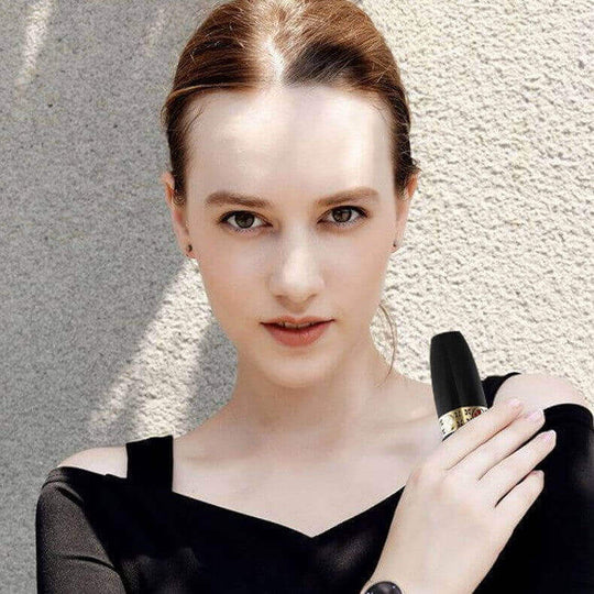 Woman holding a black USB rechargeable women's hair remover, showcasing its sleek design and ease of use.