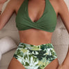 Women's multicolor high-waisted swimsuit with green halter top and tropical leaf print briefs.