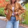 Fashion casual short suede motorcycle jacket in camel color, styled with white top and blue jeans.