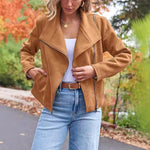 Fashion casual short suede motorcycle jacket in camel color, styled with white top and blue jeans.