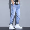Men's slim fit ankle-tied harem jeans in light blue denim, styled with white sneakers, perfect for casual wear.