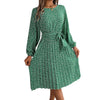 Woman wearing a green floral chiffon pleated maxi dress with long sleeves.